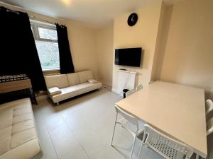 a living room with a couch and a table at 1 Bedroom flat, Close to All You Need! in Kenton