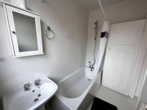 a white bathroom with a sink and a mirror at 1 Bedroom flat, Close to All You Need! in Kenton