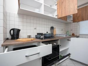 una cocina con paredes de baldosas blancas y armarios de madera. en SR24 - Stilvolle Wohnung 1 in Herten, en Herten