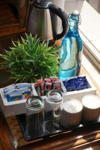 a table with a blue glass bottle and a plant at Kingscross Residency in Chennai