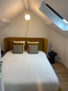 ein Schlafzimmer mit einem großen Bett mit Kissen in der Unterkunft Villa Yollande in Arcachon