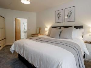 a bedroom with a large white bed with two pictures on the wall at 2 Bed in Usk 82391 in Trostrey