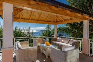 a pergola on a patio with chairs and a table at Vila petra in Prizba