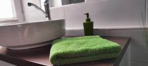a green towel sitting on a counter in a bathroom at Marianna Apartman Kaposvár in Kaposvár