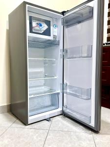 a refrigerator with its door open and a microwave inside at F.A.M Homes Tabata in Dar es Salaam
