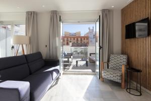 a living room with a couch and a chair at Hotel La Milagrosa in Alicante