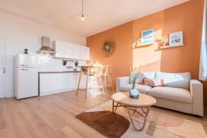 a living room with a couch and a kitchen at Hypercentre - private parking, metro + train 100m in Tourcoing