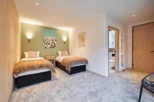 a bedroom with two beds and a bathroom at Host & Stay - Sleeper Cottage in Brompton