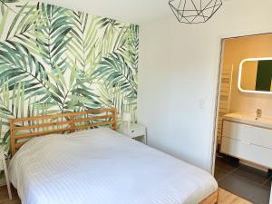 a bedroom with a bed and a tropical wallpaper at Le Forum - HYPER centre - PARKING in Reims