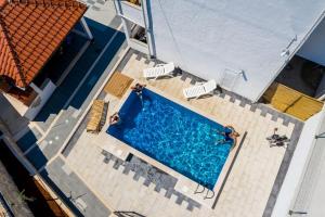 uma vista superior de uma piscina com duas cadeiras de jardim em Mata Family Apartments em Molunat