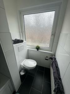 uma pequena casa de banho com um WC e uma janela em Wohnglück 2 em Herten