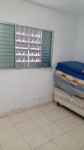 Cette chambre comprend un lit et une fenêtre. dans l'établissement Chácara Nossa Senhora Aparecida, à Ribeirão Pires