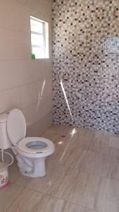 La salle de bains est pourvue de toilettes et d'une fenêtre. dans l'établissement Chácara Nossa Senhora Aparecida, à Ribeirão Pires
