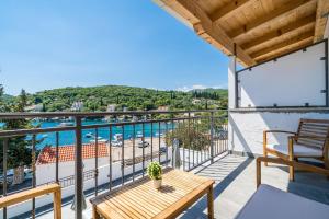 uma varanda com uma mesa e vista para a água em Mata Family Apartments em Molunat