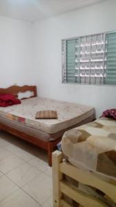 - une chambre avec 2 lits et une fenêtre dans l'établissement Chácara Nossa Senhora Aparecida, à Ribeirão Pires