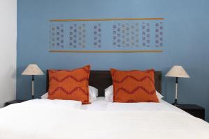 um quarto com uma cama com duas almofadas laranja em Appartementhotel am Weissensee em Weissensee