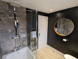 a bathroom with a bath tub and a mirror at Moorside Terrace in Guisborough