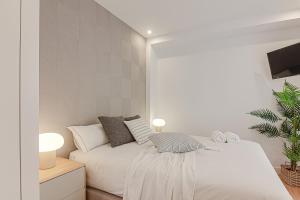 um quarto branco com uma cama e uma televisão em Santa Lucía em La Coruña
