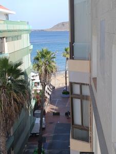 una vista della spiaggia dal balcone di un edificio di Pursuit of Ocean a Las Palmas de Gran Canaria