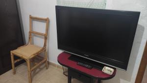 a tv sitting on a stand with a chair and a chair at Laurainu in Puerto del Rosario