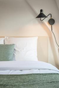 una camera da letto con un letto bianco e una lampada nera di Old Lille - Equipped and bright studio ! a Lille