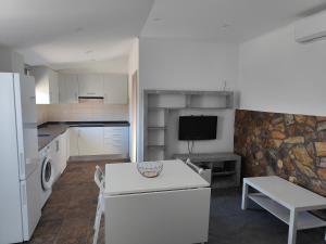 a kitchen with a refrigerator and a table and a tv at Quinta da Eira Silves in Silves