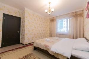 a bedroom with a bed and a window at 2 bedroom apartment on Sarayshyq street 5E in Astana