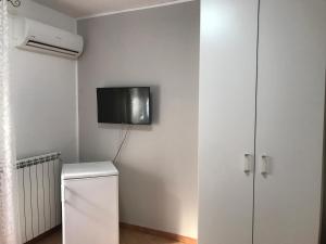 a bathroom with a tv on the wall next to a refrigerator at Busalacchi B&B in Mondello