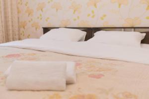 two beds with white sheets and pillows in a bedroom at 2 bedroom apartment on Sarayshyq street 5E in Astana