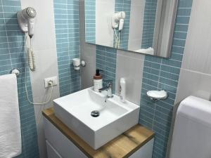 a bathroom with a white sink and a mirror at Busalacchi B&B in Mondello