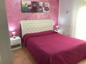 a pink bedroom with a bed with a pink bedspread at Busalacchi B&B in Mondello