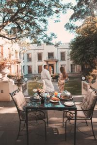 een man en een vrouw die naast een tafel met eten staan bij Fairlawns Boutique Hotel & Spa in Johannesburg