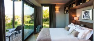 a bedroom with a large bed and a large window at Arborina Relais in La Morra