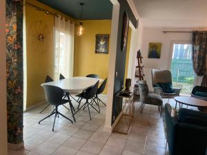 Villa Yollande في أركاشون: غرفة طعام وغرفة معيشة مع طاولة وكراسي