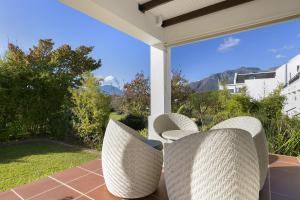 2 Korbstühle auf einer Terrasse mit Aussicht in der Unterkunft Winelands Golf Lodges 3 in Stellenbosch