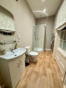 a bathroom with a toilet and a sink and a shower at The Dawnay Arms in West Heslerton