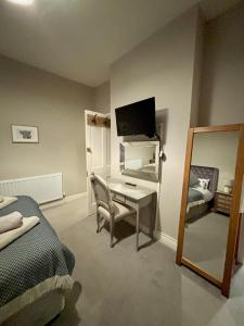a bedroom with a desk with a computer and a mirror at The Dawnay Arms in West Heslerton