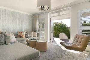 ein Wohnzimmer mit einem Sofa und einem Stuhl in der Unterkunft Winelands Golf Lodges 3 in Stellenbosch