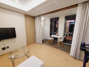 a room with a table and chairs and a tv at Best Travel in Haeundae with best location in Busan