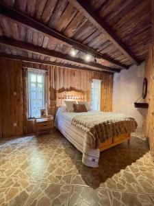 a bedroom with a large bed in a room with wooden walls at Cabañas Real Victoria in Tlalpujahua de Rayón