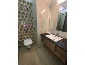 a bathroom with a sink and a toilet and a mirror at Hotel Sobti Plaza, Ambala, Haryana in Ambāla