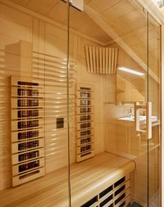 a sauna with a glass shower and a sink at Alpenstolz Damüls Haus 4 - Stilvoll urlauben in den Bergen in Damuls
