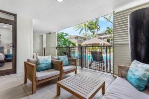 een woonkamer met een balkon met uitzicht op het zwembad bij Lagoon Breeze Swim-out Temple Resort Stay in Port Douglas