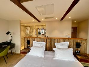 a bedroom with a large bed with white pillows at Hôtel La Garenne in Saverne