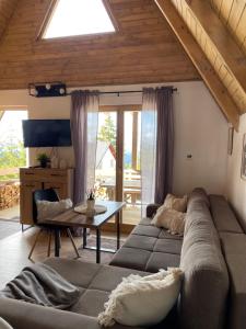 ein Wohnzimmer mit einem Sofa und einem Tisch in der Unterkunft Obiteljska oaza Vlašić in Vlasic