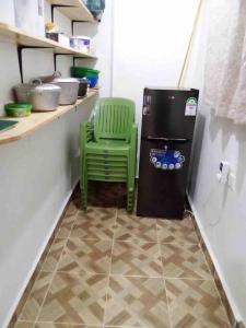 a green chair next to a refrigerator in a kitchen at Zen House in Kakamega