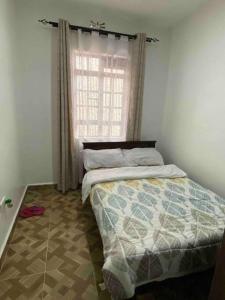 a bedroom with a bed and a window at Zen House in Kakamega