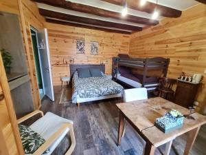 a room with a bed and a table in a cabin at La Flambée in Blond