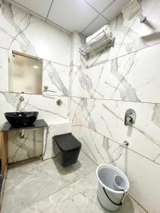 ラージコートにあるHotel Royal Eliteのバスルーム(洗面台、トイレ、鏡付)
