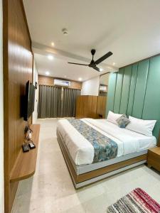 a bedroom with a bed and a flat screen tv at Hotel Royal Elite in Rajkot